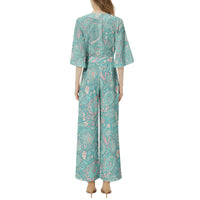 Women's pastel paisley jumpsuit with turquoise botanical print, notch neckline, and flowing wide leg silhouette