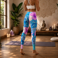 Tropical hibiscus floral leggings in vibrant blue and pink with a colorful botanical print, designed as island-inspired activewear and statement streetwear