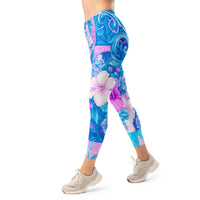 Tropical hibiscus floral leggings in vibrant blue and pink with a colorful botanical print, designed as island-inspired activewear and statement streetwear