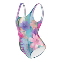 Colorful one-piece swimsuit featuring aqua blue, pink, lavender, and pastel floral watercolor print for beach and resort wear