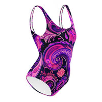 One-piece swimsuit with a bold black, pink, and purple psychedelic floral and paisley print