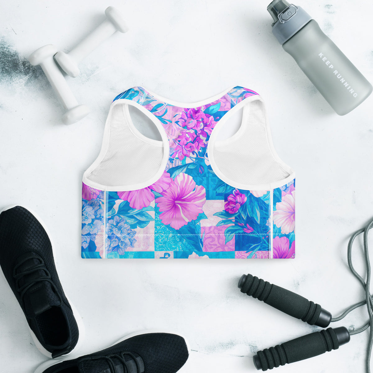 Tropical hibiscus sports bra in vibrant blue with pink floral botanical print, featuring padded moisture-wicking fabric for stylish activewear and workout