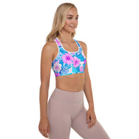 Tropical hibiscus sports bra in vibrant blue with pink floral botanical print, featuring padded moisture-wicking fabric for stylish activewear and workout