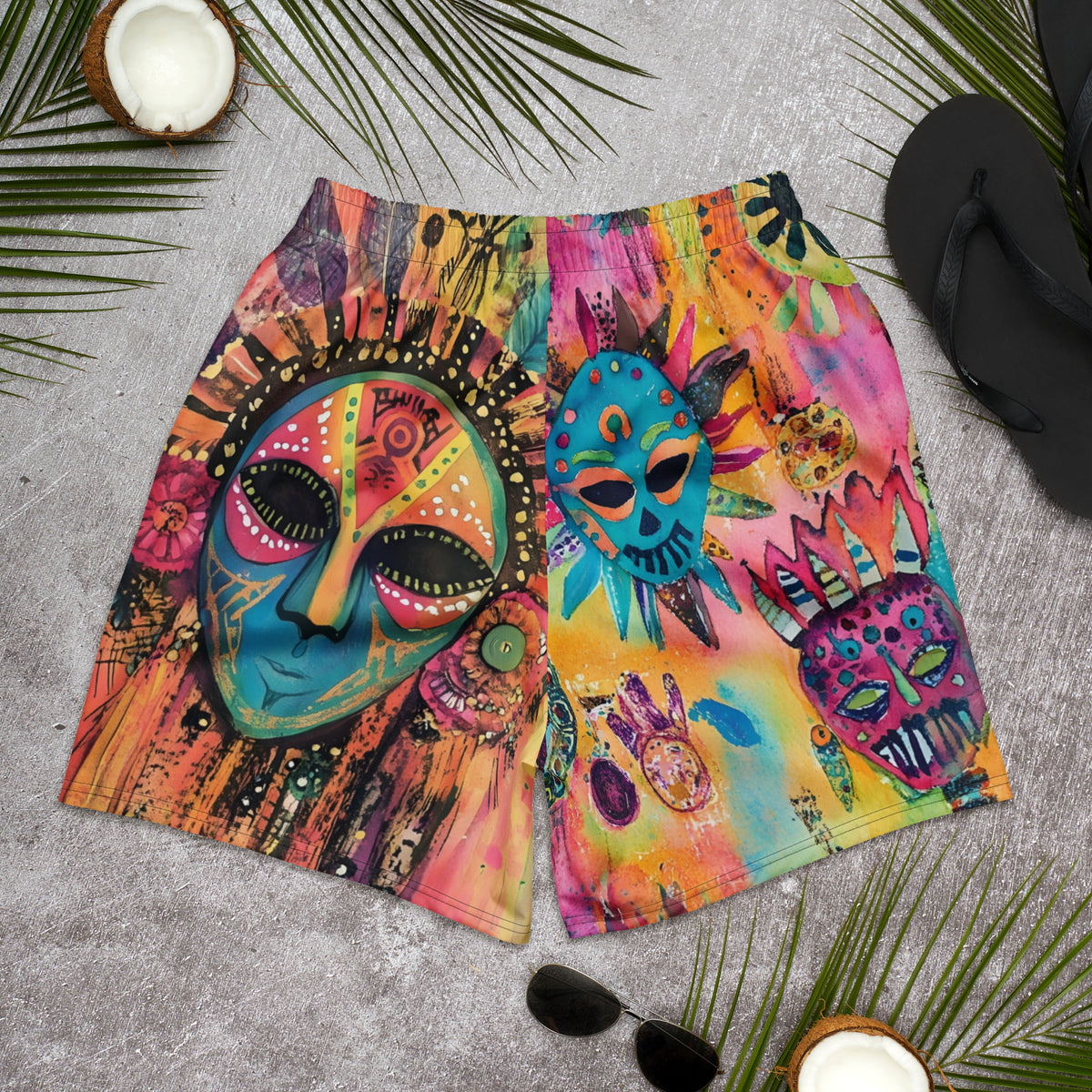 Long sports shorts featuring a vibrant psychedelic tribal mask print with expressive painted faces, decorative folk-art symbols, abstract shapes, brushstrokes, and colorful collage-like textures in turquoise, teal, coral, pink, magenta, orange, yellow, purple, black, and earthy tones. Unisex athletic design with a longer cut, elastic waistband, and bold artistic all-over pattern