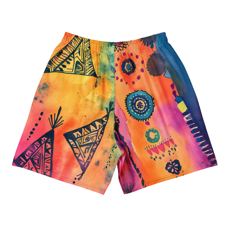 Aztec-inspired long sports shorts featuring a colorful tribal geometric abstract print with triangles, sun-like symbols, dots, decorative linework, and organic motifs in yellow, orange, coral, pink, magenta, purple, turquoise, teal, and navy. Long athletic cut with elastic waistband and white drawstring