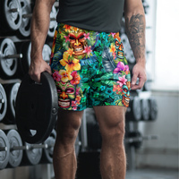 Tropical Tiki performance shorts featuring vibrant tiki mask artwork with hibiscus flowers and jungle leaves in bold tropical streetwear design