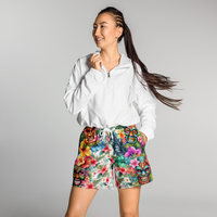 Tropical Tiki performance shorts featuring vibrant tiki mask artwork with hibiscus flowers and jungle leaves in bold tropical streetwear design