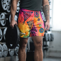 Aztec-inspired long sports shorts featuring a colorful tribal geometric abstract print with triangles, sun-like symbols, dots, decorative linework, and organic motifs in yellow, orange, coral, pink, magenta, purple, turquoise, teal, and navy. Long athletic cut with elastic waistband and white drawstring