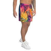 Aztec-inspired long sports shorts featuring a colorful tribal geometric abstract print with triangles, sun-like symbols, dots, decorative linework, and organic motifs in yellow, orange, coral, pink, magenta, purple, turquoise, teal, and navy. Long athletic cut with elastic waistband and white drawstring