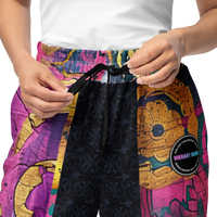 Unisex wide-leg joggers with abstract color block print in turquoise, magenta, deep pink, and gold accents
