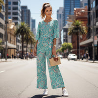 Women's pastel paisley jumpsuit with turquoise botanical print, notch neckline, and flowing wide leg silhouette
