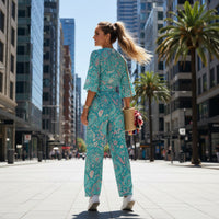 Women's pastel paisley jumpsuit with turquoise botanical print, notch neckline, and flowing wide leg silhouette